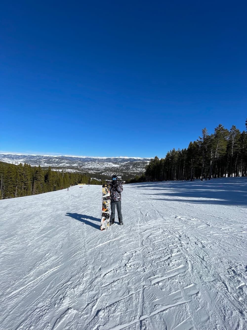 Andrea snowboarding on a scenic mountain slope in Colorado